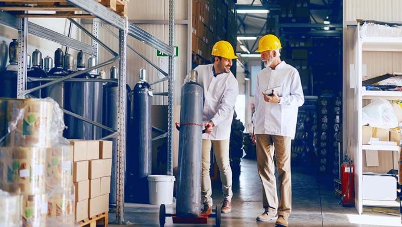Mitarbeiter im Lager mit Gasflaschen als Beispiel für sichere Gasflaschenlagerung im Gewerbe